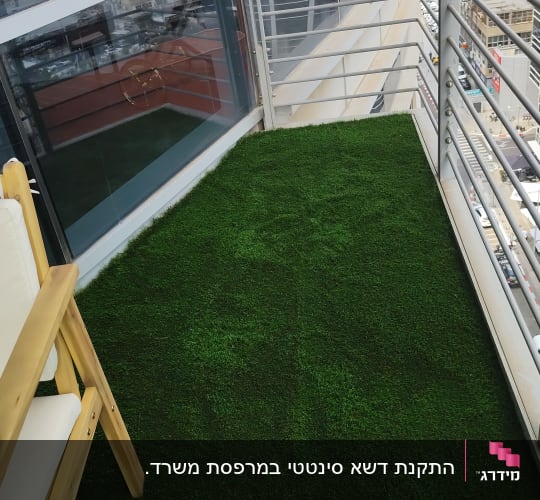 מרפסת עם דשא סינתטי וכיסא עץ